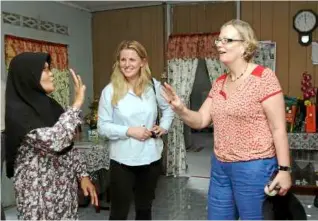  ??  ?? Felda settler Samaayah dahalan, 61, takes mePs emma mcclarkin (left) and Girling on a tour of her house, in besout 2.