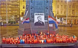  ?? (AFP) ?? Lit candles and flags are placed in tribute to Gen Slobodan Praljak in Zagreb on November 30 after the Bosnian Croat war criminal took his own life in front of United Nations war crimes judges