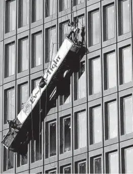  ?? JERRYJACKS­ON/BALTIMORE SUN ?? Workers hold on to a dangling scaffoldin­g after an explosion Wednesday morning in downtown Baltimore.