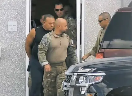  ?? WPLG-TV via AP ?? This frame grab from video provided by WPLG-TV shows FBI agents escorting Cesar Sayoc, in sleeveless shirt, in Miramar, Fla., on Friday. Mr. Sayoc is an amateur bodybuilde­r with a lengthy arrest record.