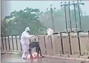  ??  ?? A video grab of the two men throwing a Covid patient’s body from the parapet of a bridge into Rapti river in UP’s Balrampur.