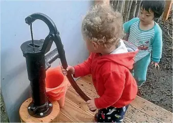  ??  ?? Connor Turkington checks out the new pump built in an upgrade to Titahi Bay Playcentre.