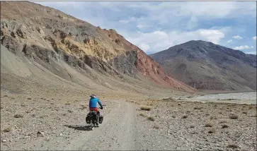  ??  ?? Mike Curran cycling in Kyrgyzstan on the long road home from China to Kerry with his girlfriend Sara O’Shea.