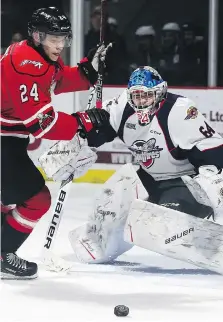  ?? DAN JANISSE ?? Spitfires goalie Michael DiPietro and Maksim Sushko of the Owen Sound Attack eye a bouncing puck Thursday during OHL action at the WFCU Centre.