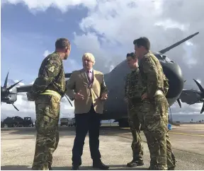  ?? AFP; PA ?? French president Emmanuel Macron, left, comforts medical staff during a visit to the French Caribbean island of St Martin. Right, UK foreign secretary Boris Johnson talks to the crew of an RAF transport aircraft in Barbados, where he stopped on his way...