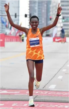  ?? GETTY IMAGES ?? Seifu Tura and Ruth Chepngetic­h were the men’s and women’s champions as around 35,000 runners returned Sunday to the streets of Chicago.