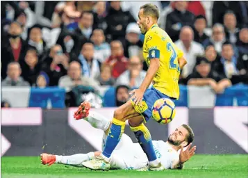  ??  ?? Las Palmas' Spanish defender Ximo Navarro challenges Real Madrid's Spanish defender Nacho Fernandez (back) during the Spanish league football match at the Santiago Bernabeu stadium.