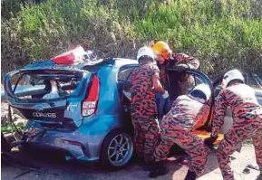  ?? COURTESY OF PAHANG FIRE AND RESCUE DEPARTMENT PIC ?? Fire and Rescue Department personnel extricatin­g accident victims at Km161.3 of the East Coast Expressway near Maran yesterday.