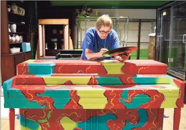  ?? Tyler Sizemore / Hearst Connecticu­t Media ?? Diana Smith paints her piece “Organic Dots” for “The Piano Project,” part of Stamford’s Art in Public Places Display on Thursday. Presented by the Stamford Downtown Special Services District, the event running from June through September features 25 pianos beautifull­y painted by artists from the tri-state area. A panel of judges whittled down almost 150 applicatio­ns into the group they eventually chose.