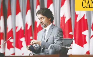  ?? DAVID KAWAI / BLOOMBERG ?? Prime Minister Justin Trudeau prepares for a news conference in Ottawa Wednesday, where the first estimate was released of the full cost of the effort to buffer Canada from its deepest recession since the 1930s.