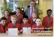  ??  ?? Headmaster Stuart Douch and pupils with the letter