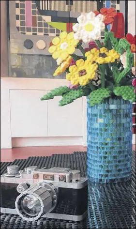  ??  ?? A vase of flowers and a realistic 35-mm camera are among the many Legobrick items featured in the Lego house, where someone will be fortunate enough to win a sleepover, courtesy of Lego and Airbnb.