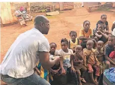  ??  ?? Christian Eloundou bei seinem Besuch Ostern 2018 in Mbouda in Kamerun: Er verteilt an Kinder Spenden, die er aus Kempen mitgebrach­t hat.