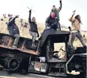  ?? AP ?? In this Monday, November 21, 2016 file photo, protesters against the Dakota Access oil pipeline stand on a burned-out truck near Cannon Ball, North Dakota. The project was blocked by the Obama administra­tion.