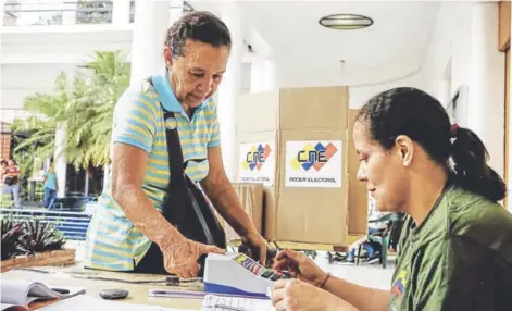  ??  ?? ► Una mujer se registra para votar durante las elecciones de ayer en Caracas.