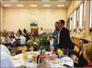  ?? ?? Ukrainian refugees Simon Bobrovskii and his wife, Daria Sakhniuk, are welcomed during an Easter luncheon at St. Michael the Archangel Ukrainian Catholic Church in New Haven on Sunday.