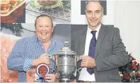  ??  ?? John Buchan from Auchtydore Farms is presented with the Perpetual Challenge cup by Hugh Dunlop, chairman of the Fat Stock Club, for best prime cow