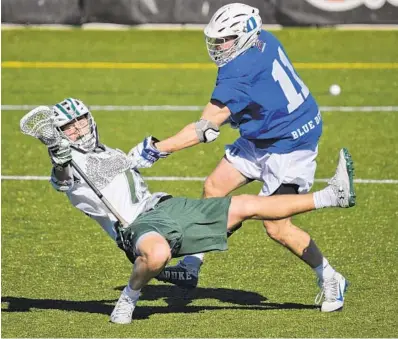  ?? KARL MERTON FERRON/THE BALTIMORE SUN ?? Duke midfielder Terry Lindsay sends Loyola midfielder Peter Swindell tumbling backward during Saturday afternoon’s game.