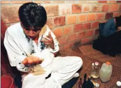  ?? AFP JAIME RAZURI/ ?? A healer blows tobacco into his hands to start an ayahuasca ceremony in Tarapoto, northeaste­rn jungle of Peru in February 1999.