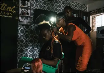  ?? PHOTOS: TOM SAATER — THE NEW YORK TIMES ?? In Lagos, Nigeria, stylists at a salon that can't find affordable fuel for a gas-powered generator turn to their cellphones for light. A spike in energy prices is having a cascading effect around the world.