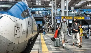  ?? — AFP ?? Tough call: Passengers prepare to board a train at Seoul station. The South Korean manufactur­ing sector contracted again in August and the central bank says the best way to safeguard the economy is to contain price rises.