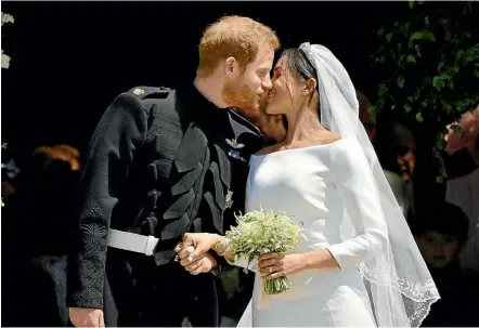  ?? GETTY IMAGES ?? Prince Harry and Meghan Markle kiss on the steps of St George’s Chapel in Windsor Castle after their wedding in St George’s Chapel at Windsor Castle.