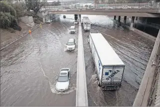  ?? Brian van der Brug Los Angeles Times ?? CALIFORNIA Highway Patrol officers limit traffic to just one lane in each direction on a f looded portion of the 5 Freeway in Sun Valley as Caltrans workers try to clear storm drains.