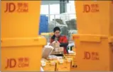  ?? JIAO HONGTAO / FOR CHINA DAILY ?? An employee of JD in Xi’an, Shaanxi province, sorts delivery packages.