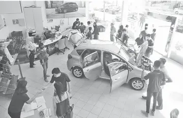  ??  ?? Customers check out the Perodua Myvi 1.3X at Perocom’s Auto showroom.