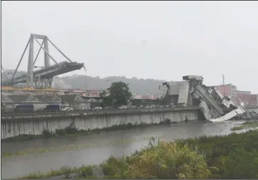  ?? The Associated Press ?? MORANDI HIGHWAY BRIDGE: A view of the collapsed Morandi highway bridge in Genoa, northern Italy, Tuesday. A large section of the bridge collapsed over an industrial area in the Italian city of Genova during a sudden and violent storm, leaving vehicles crushed in rubble below.