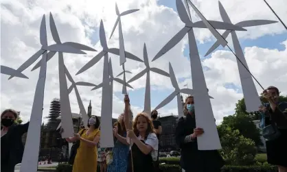  ?? Photograph: Barcroft Media/Getty Images ?? Parents and children hold handmade wind turbines, creating a wind farm, in Parliament Square before a march to Downing Street to call for a green economic recovery.