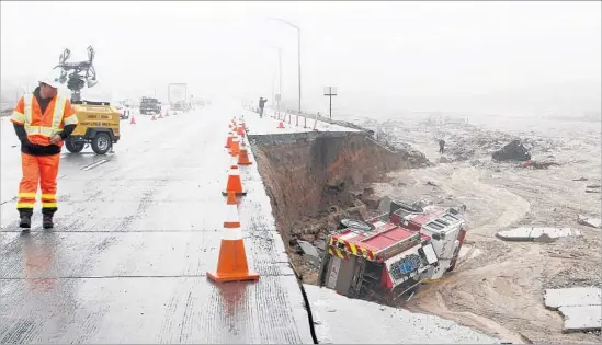  ?? Irfan Khan Los Angeles Times ?? HEAVY RAIN in Cajon Pass caused a San Bernardino firetruck to topple off Interstate 15. Caltrans estimates emergency repairs on the highway will cost $3 million.