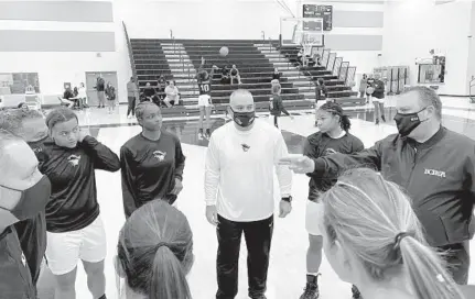  ?? ADAM LICHTENSTE­IN/SOUTH FLORIDA SUN SENTINEL ?? American Heritage girls basketball coach Greg Farias, center, and three captains meet with Miami Country Day’s coach and captains before their game on Tuesday.