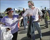  ?? Irfan Khan Los Angeles Times ?? GOV. GAVIN NEWSOM greets a worker at the opening of the Dodger Stadium mass vaccine site in January. Newsom said supply issues remain a hurdle.