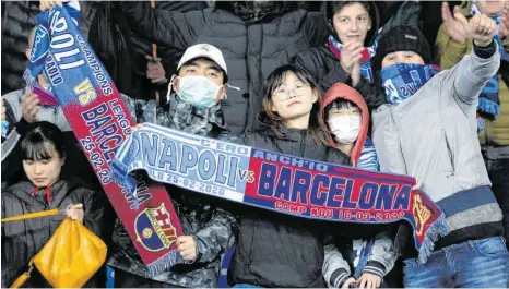  ?? FOTO: ANDREW MEDICHINI/DPA ?? Auch mit Mundschutz schaut es sich ganz gut: Asiatische Zuschauer treffen beim Spiel zwischen Neapel und Barcelona Vorsorge.
