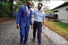  ?? BRYNN ANDERSON/ASSOCIATED PRESS ?? Democratic­U.S. Senate candidates RaphaelWar­nock (left) and JonOssoffa­rriveat a “GetOut theEarlyVo­te” eventTuesd­ayat the SluttyVega­nATL restaurant in Jonesboro. Ossoffis challengin­g Republican incumbent David Perdue.