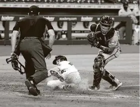  ?? Karen Warren / Staff photograph­er ?? Alex Bregman slides home with the Astros’ fourth run after beating the throw to Giants catcher Chadwick Tromp.