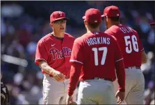  ?? THE ASSOCIATED PRESS ?? Phillies manager Joe Girardi, left, pulls starter Zach Eflin, right, against the Colorado Rockies in Denver last month as Rhys Hoskins looks on.
