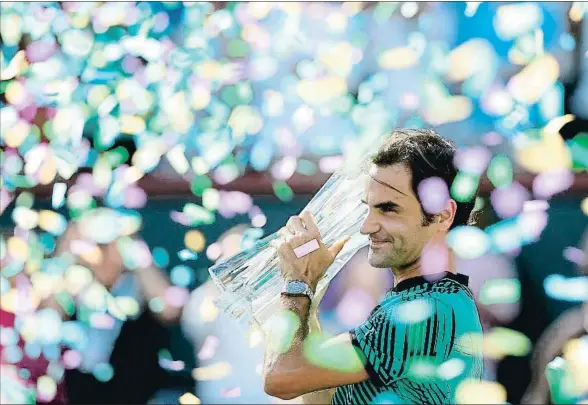  ?? MATTHEW STOCKMAN / AFP ?? El suizo, envuelto por el confeti, levanta el trofeo en la pista california­na de Indian Wells