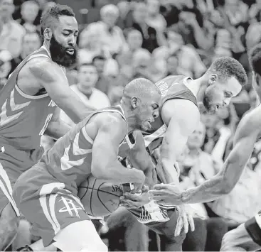  ?? Brett Coomer / Houston Chronicle ?? Rockets guard Chris Paul, center, takes the ball from Warriors guard Stephen Curry, right, during the fourth quarter Saturday night at Toyota Center.