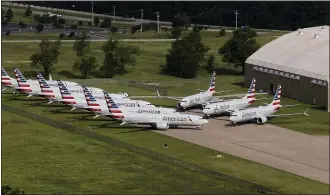  ?? TOM GILBERT/TULSA WORLD VIA AP ?? In a May 24 aerial photo, American Airlines 737 Max are stored at Tulsa Internatio­nal Airport. Boeing Co. said Monday, Dec. 16that it will temporaril­y stop producing its grounded 737Max jet starting in January 2020as it struggles to get approval from regulators to put the plane back in the air.