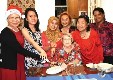  ??  ?? Florence (seated) and other members jointly cut the Christmas cake during the AGM-cum-Christmas gathering.