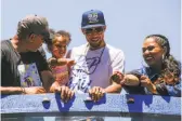  ?? Gabrielle Lurie / The Chronicle ?? Stephen Curry (center) and family members enjoy the Warriors’ parade.