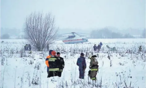  ??  ?? ► Servicios de emergencia trabajan donde se estrelló el avión Antonov AN-148, en las afueras de Moscú.