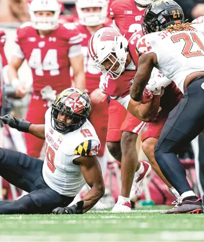  ?? ANDY MANIS/AP ?? Wisconsin running back Jackson Acker, center, is pursued by Maryland linebacker Ahmad McCullough, left, and linebacker Gereme Spraggins during the second half Saturday.