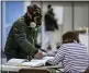  ?? THE JANESVILLE GAZETTE VIA AP ?? Robert Forrestal wears a full-face chemical shield to protect against the spread of coronaviru­s, as he votes Tuesday in Janesville, Wis.