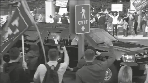  ?? ASSOCIATED PRESS ?? IN THIS IMAGE FROM VIDEO, PRESIDENT DONALD TRUMP waves as he drives past supporters gathered outside Walter Reed National Military Medical Center in Bethesda, Md., on Sunday. Trump was admitted to the hospital after contractin­g COVID-19.