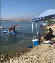  ?? RECORDER PHOTOS BY ESTHER AVILA ?? Romualto Ayala and Juanita Perez ride away on their Yamaha jet ski Sunday at Success Lake. The family, from Woodlake, arrived Sunday morning and said they planned on staying all day.