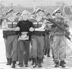  ??  ?? Turkish Gendarmeri­e escort defendants Akin Ozturk (second left) and others involved in last July’s attempted coup in Turkey as they leave the prison where they are being held, ahead of their trial in Ankara. — AFP photo