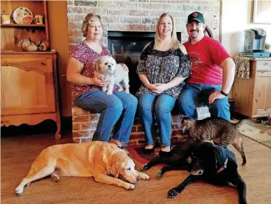  ?? [PHOTOS PROVIDED BY SHERRY LOPATIC] ?? Sherry Lopatic, left, her daughter and son-in-law Rachel and Michael Tidwell, and shih tzu Grace, yellow Lab Kit, black Lab Sadie, and Harley the cat, in their home in Choctaw.